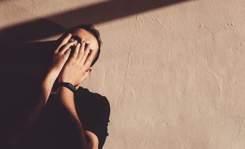 Portrait of man standing against wall