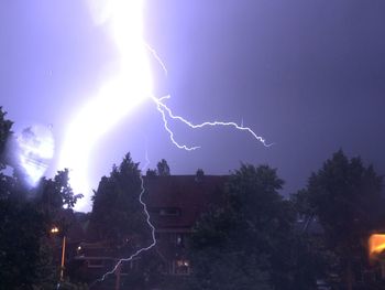 Lightning over trees at night