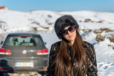 Portrait of woman standing on snow covered land