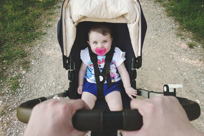 Portrait of cute girl in baby stroller