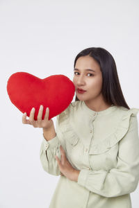 Portrait of beautiful young woman against white background