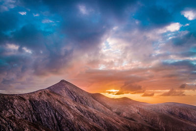 Scenic view of mountains against sky at sunset