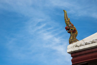 Low angle view of statue of building against cloudy sky