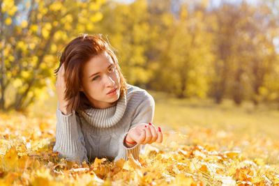 Happy woman in autumn season relax. brunette girl lying and smiling at autumn