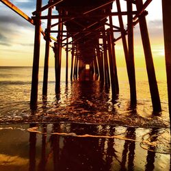 Pier over sea at sunset