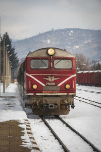 Train on railroad track against sky during winter