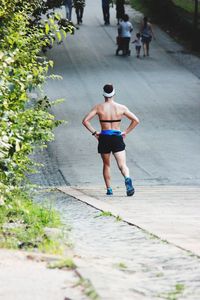 Rear view of woman running on footpath