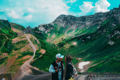 People on mountain against sky