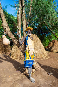 Man standing by tree trunk