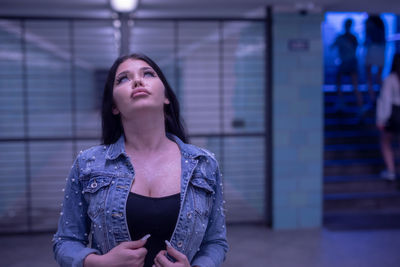 Fashionable young woman standing in illuminated built structure