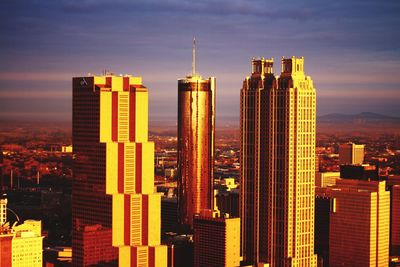 Illuminated cityscape against sky during sunset