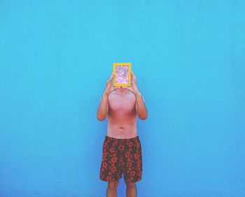 Girl standing against blue wall