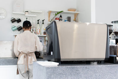 Rear view of woman standing at home