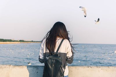 Side view of woman on shore against sea