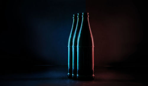 Close-up of glass bottle on table against black background