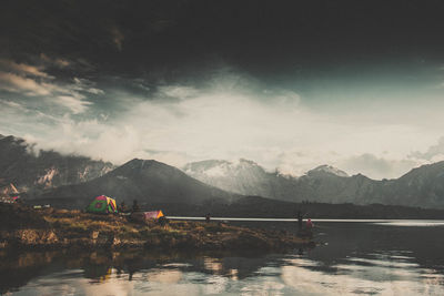 Scenic view of lake by mountains against sky