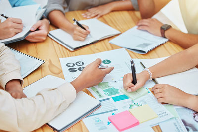 Midsection of business colleagues working on table