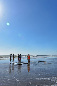 People at beach against sky