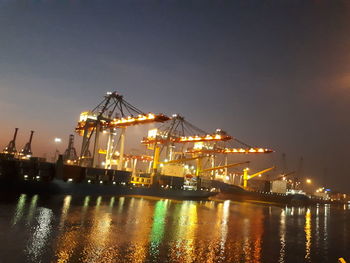 Illuminated commercial dock against sky at night