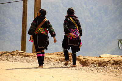 Rear view of people walking on beach