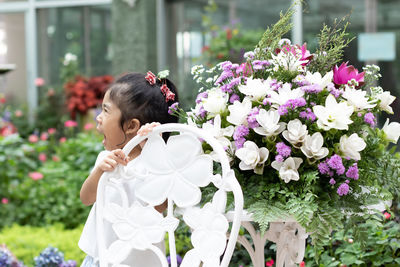 Rear view of woman with pink flowering plants