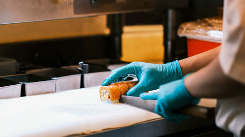 Chef cutting salmon on kitchen counter in restaurant