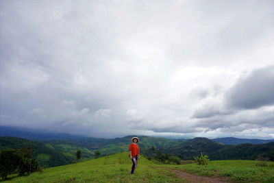 Rear view of man on field against sky