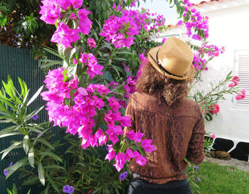 Rear view of woman with pink flowering plants