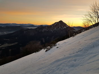 Scenic view of snow covered mountains against sky during sunset