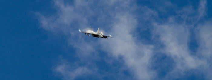 Low angle view of military airplane flying against sky