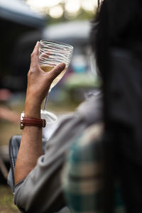 A woman holding a glass of white wine while camping.