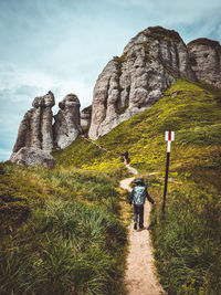 Rear view of people on rock against sky