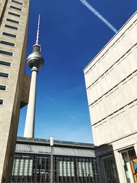 Low angle view of communications tower in city