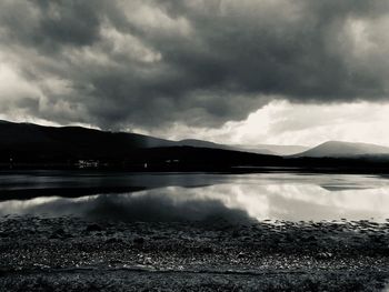 Scenic view of lake against cloudy sky