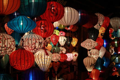 Multi colored lanterns hanging for sale at market during night