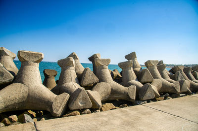 Low angle view of rocks against clear blue sky