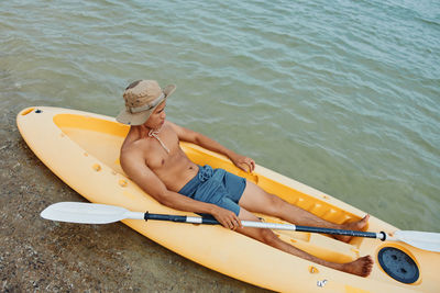 Rear view of woman kayaking in lake