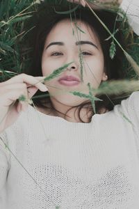 Portrait of young woman holding plant