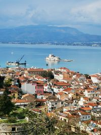 High angle view of townscape by sea against sky