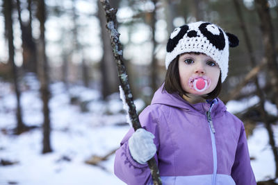 A winter portrait of a little girl in the woods.