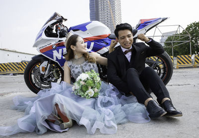 Portrait of happy friends sitting on motorcycle