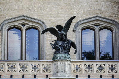 Low angle view of statue against historic building