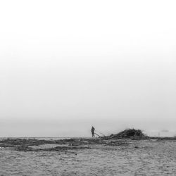 Man standing on beach against clear sky