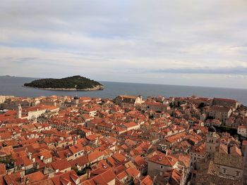 High angle view of townscape by sea against sky