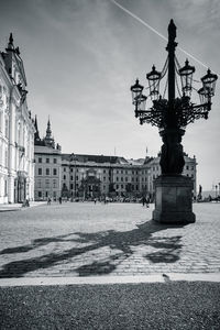 Statue in city against cloudy sky