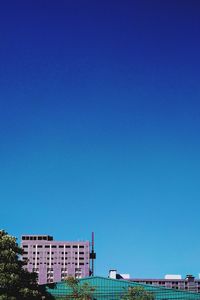 Low angle view of buildings against clear blue sky