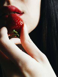 Close-up of hand holding strawberry