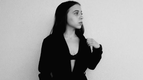 Young woman standing against white background