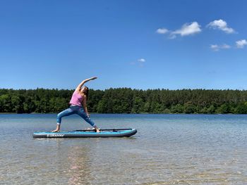 Woman in lake against sky