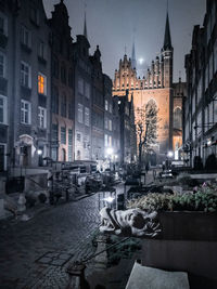Street amidst illuminated buildings in city at night